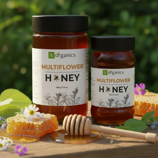 Multiflower forest honey by IK Organics on a natural background with a honey dip stick and multiple flowers